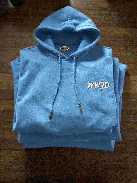 Light blue hoodie with 'WWJD' text on a wooden surface
